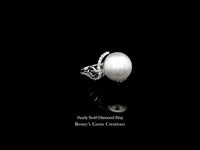 Pearly Swirl Diamond Ring featuring an elegant swirl design adorned with brilliant diamonds and a lustrous pearl centerpiece set in fine gold.